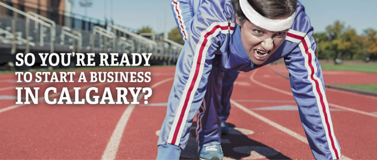 start a business in calgary - a woman in a track suit, leaned into starting blocks on a running track