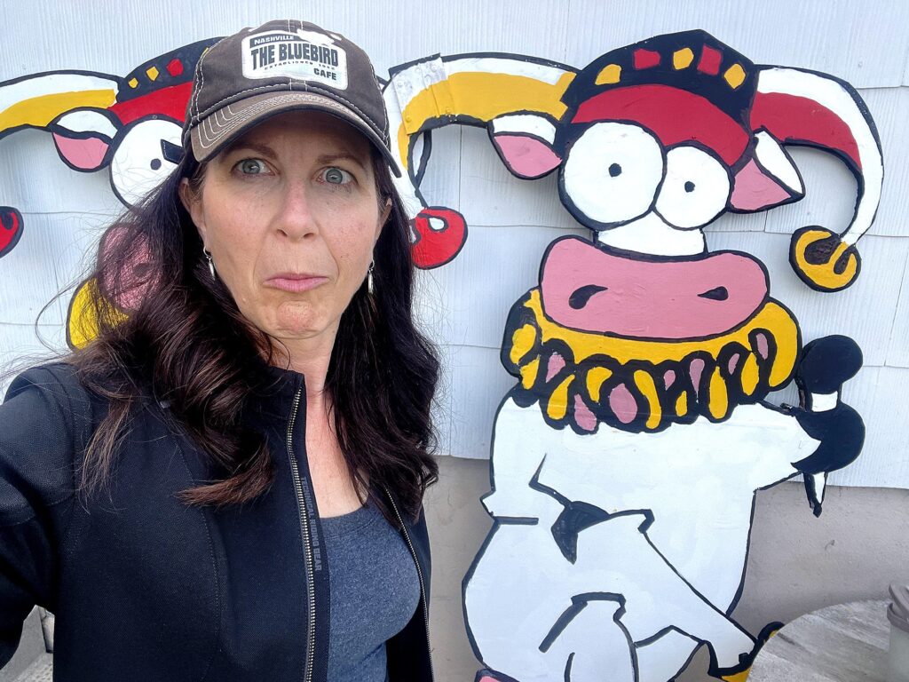 Tenato CEO and marketing consultant Jacqueline Drew making a funny face in front of the FunnyFest Comedy cow mascot